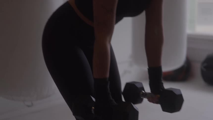 The woman is lifting two barbells in the gym