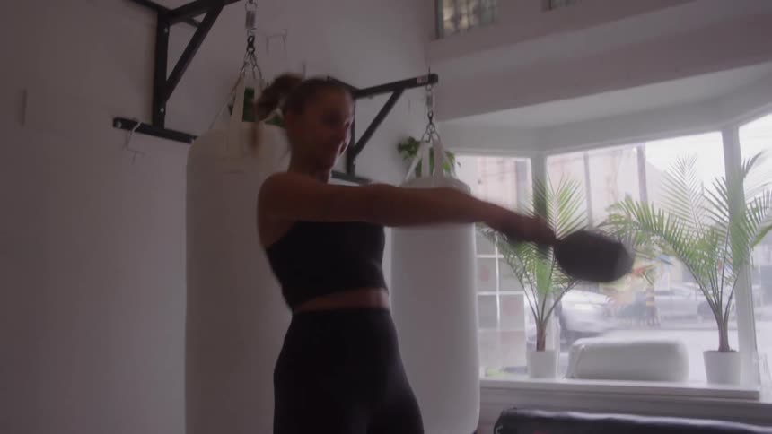 Woman training with a kettlebell in a gym setting