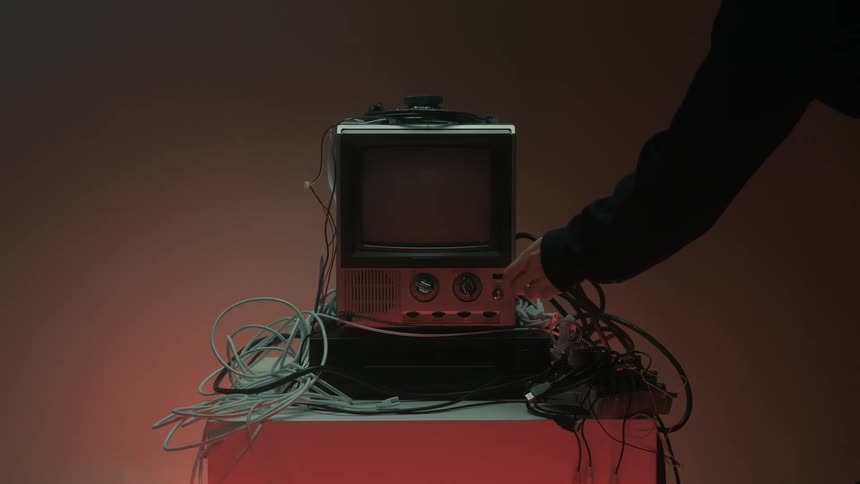 Person turns the knob on an old television and turns it off