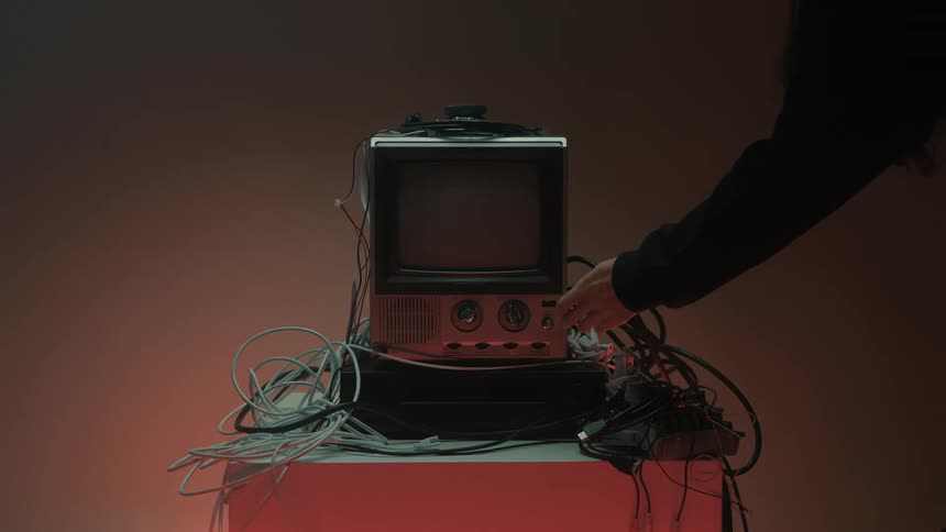 Person presses the button on an old television and turns it off