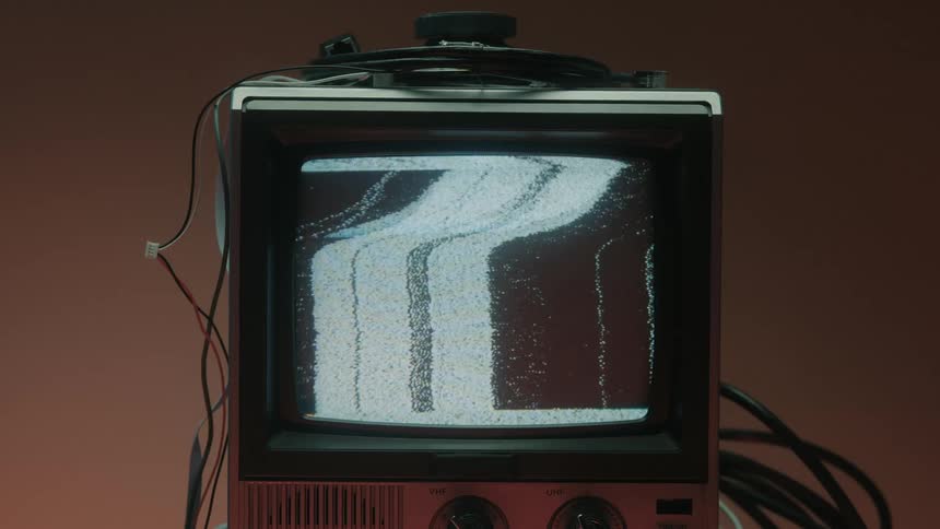 Close up of a connected electronic display device showing a static screen in a red lit room