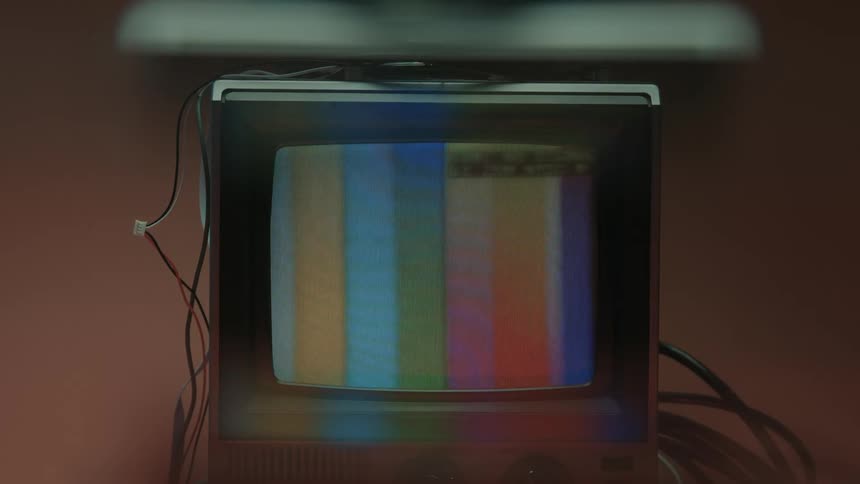 The television surrounded by wires is turned on