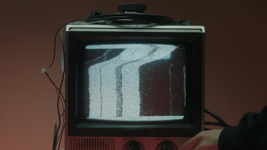 Old television displays distorted noise with vertical bands on the screen