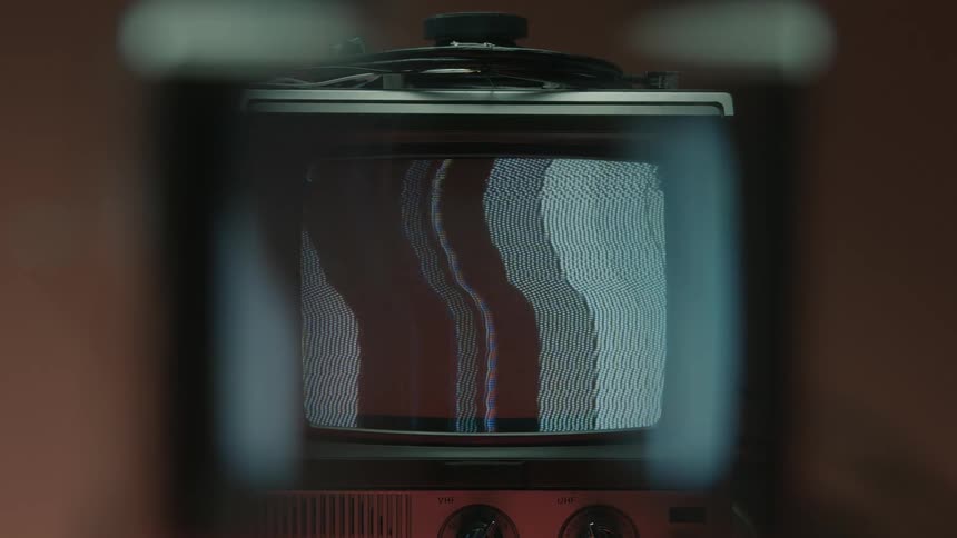 A vintage television screen viewed through a distorted lens displays classic static with warped horizontal lines