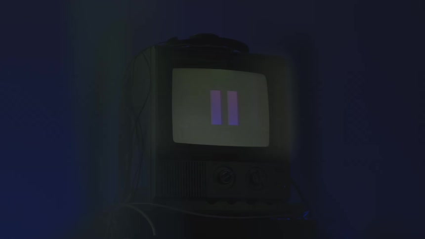 A digital electronic device displays various logos and shapes in sequence inside a dark room