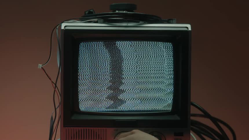 The person repeatedly turns the knob on the television