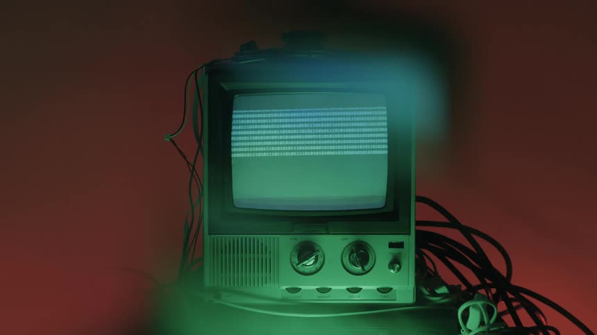 The television in the dark room is displaying numbers