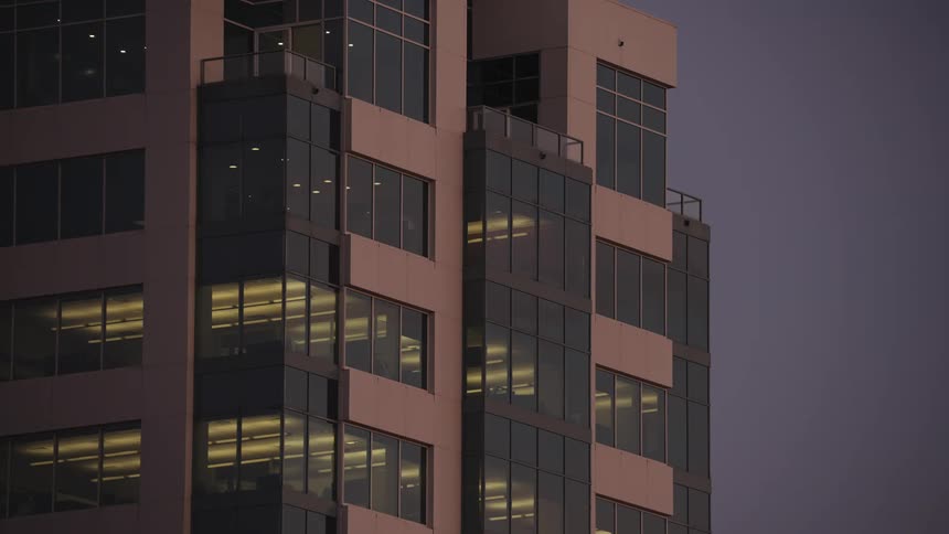 The lights come on inside the building as the sun sets