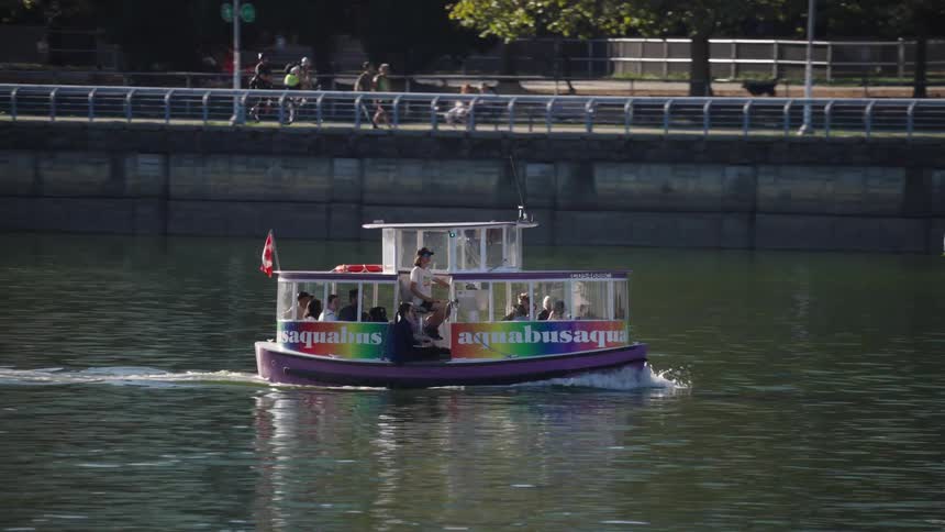 Colorful boat carrying people on a river near a dock