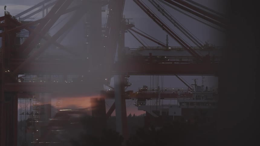 Cranes and port structures illuminated at dusk