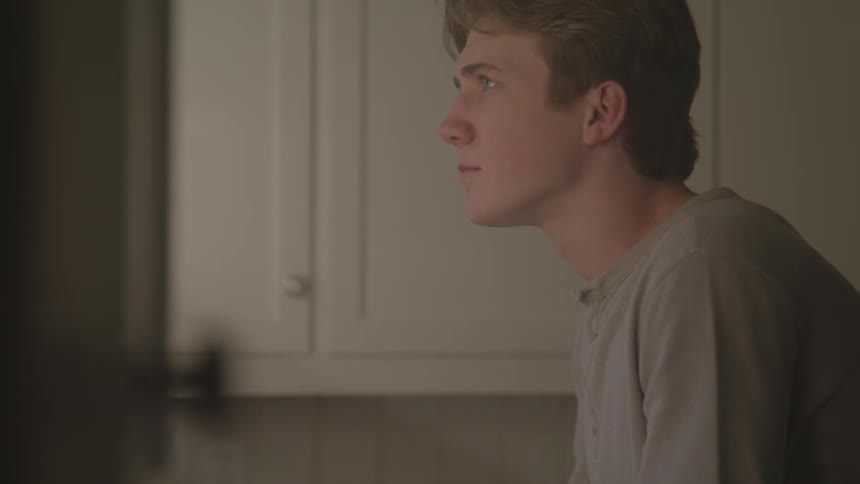 Man with head down appearing sad in an indoor setting