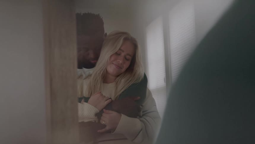 The couple are hugging in front of the mirror