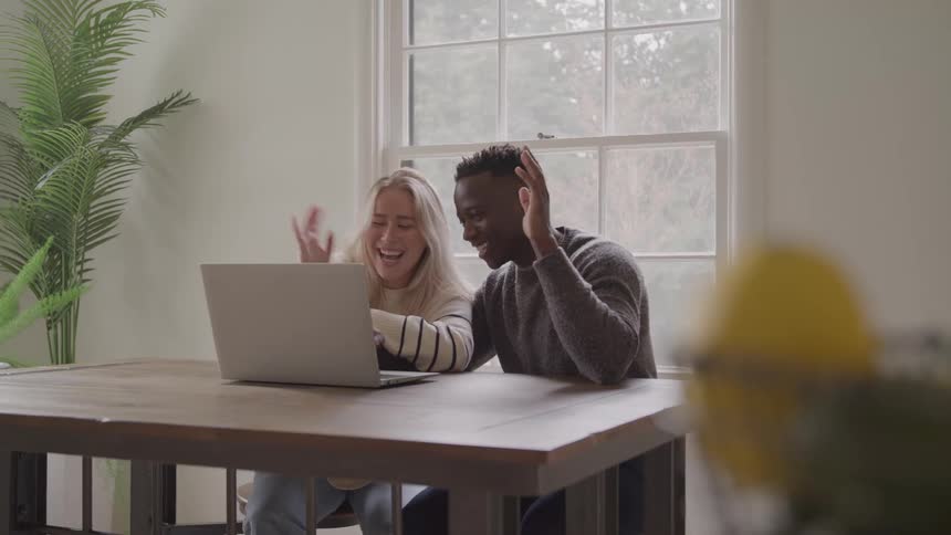 A young boy and girl interacting with a laptop in an indoor setting