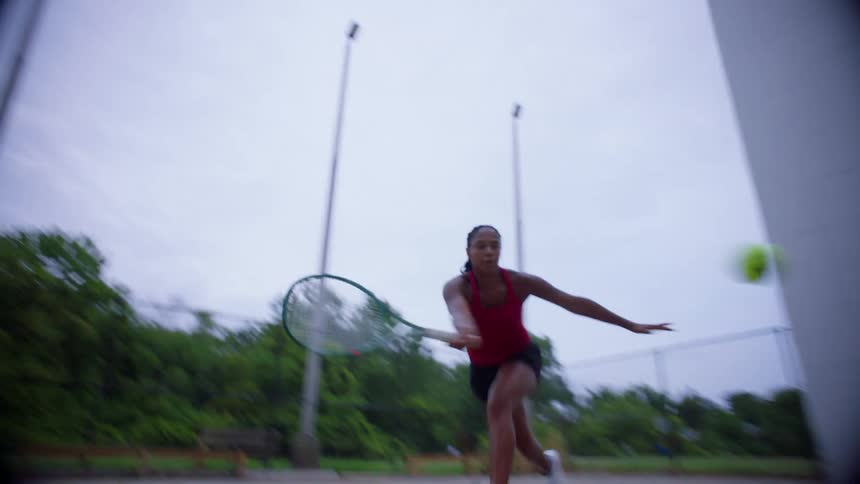 The woman hits the tennis ball with her racket