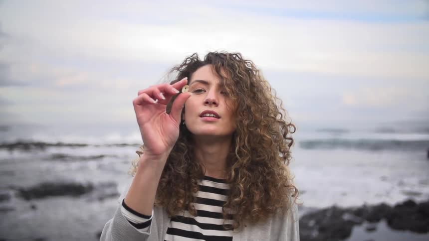 Woman examining a shell on the beach