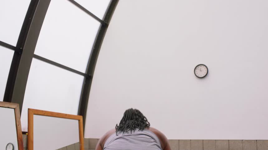 Person stretches their arms in an indoor space lit by natural light