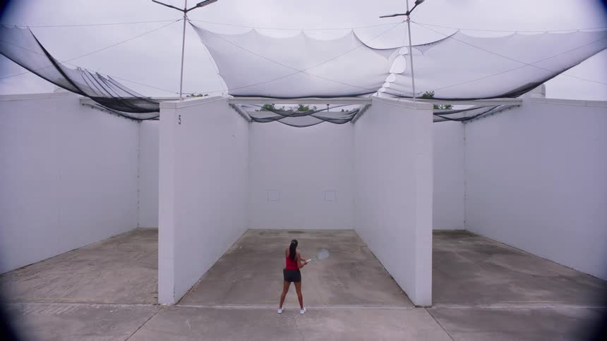 Woman practices tennis in sportswear on an outdoor court