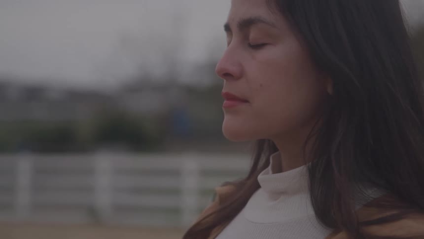 Woman with closed eyes enjoying a moment of tranquility outdoors