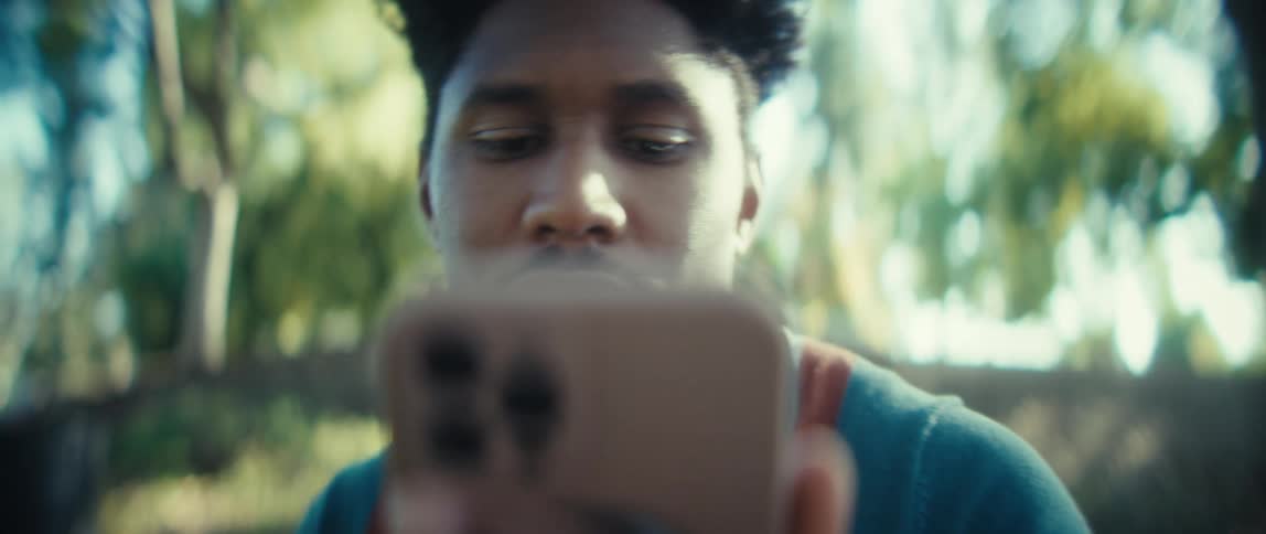 Man looks attentively at the phone in an outdoor setting