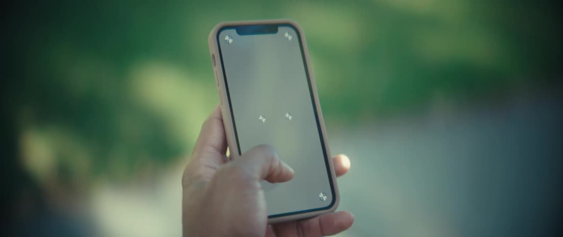 Person holding a smartphone with the screen on outdoors