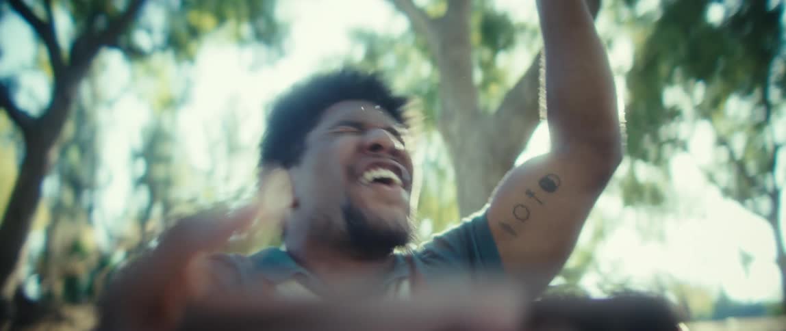 The man pumps his fist and cheers while looking at his cell phone