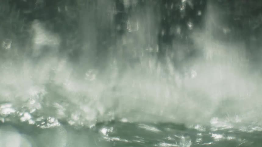 Waterfall creates splashes and foam as it hits the surface