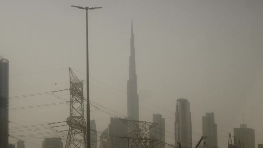 A view of some buildings in a huge skyscraper in the center in contrast with the sky and whitish