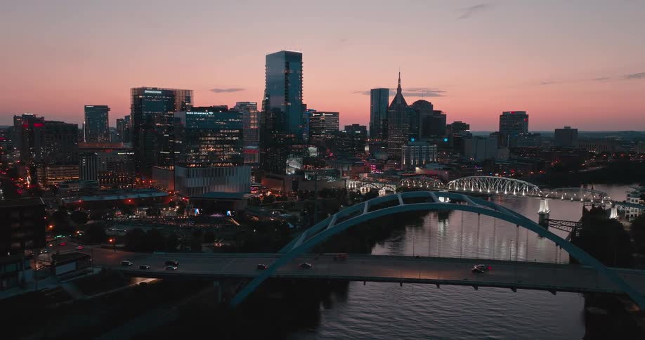 Urban skyline reflected on the river beneath the pink dusk sky