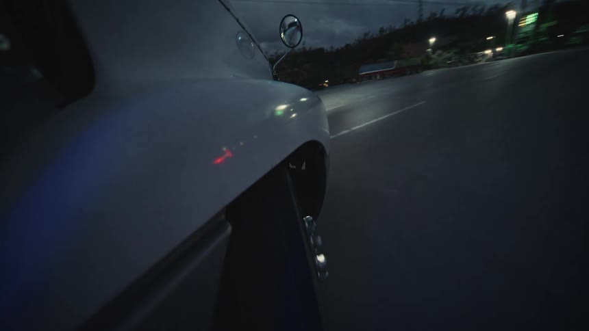 The car turns and drives into the parking lot