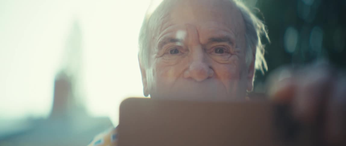 Vibrant and happy elderly man watching on a smartphone