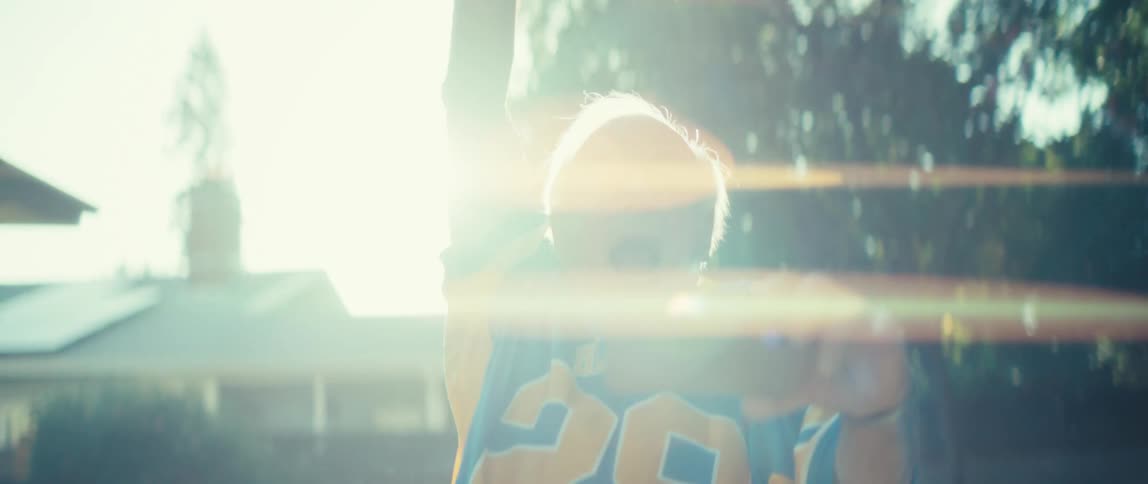 Elderly man happily raising his arms in celebration while watching on a smartphone