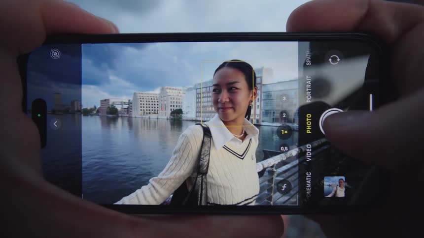The woman is having her picture taken on the bridge
