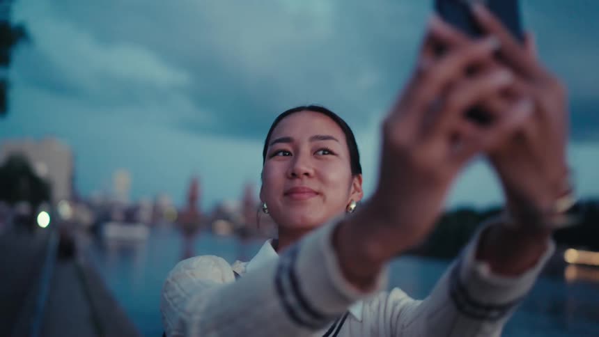Woman by a lake taking a selfie