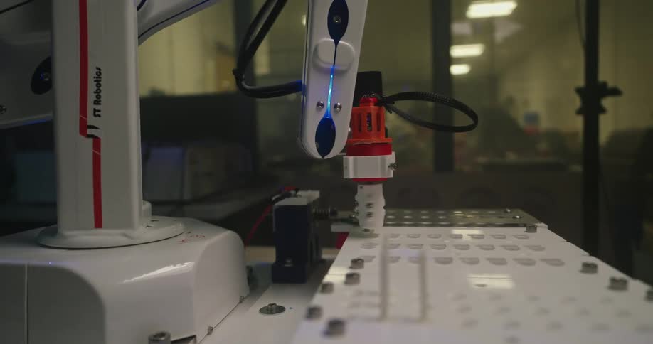 The robotic arm moves a drill into a hole
