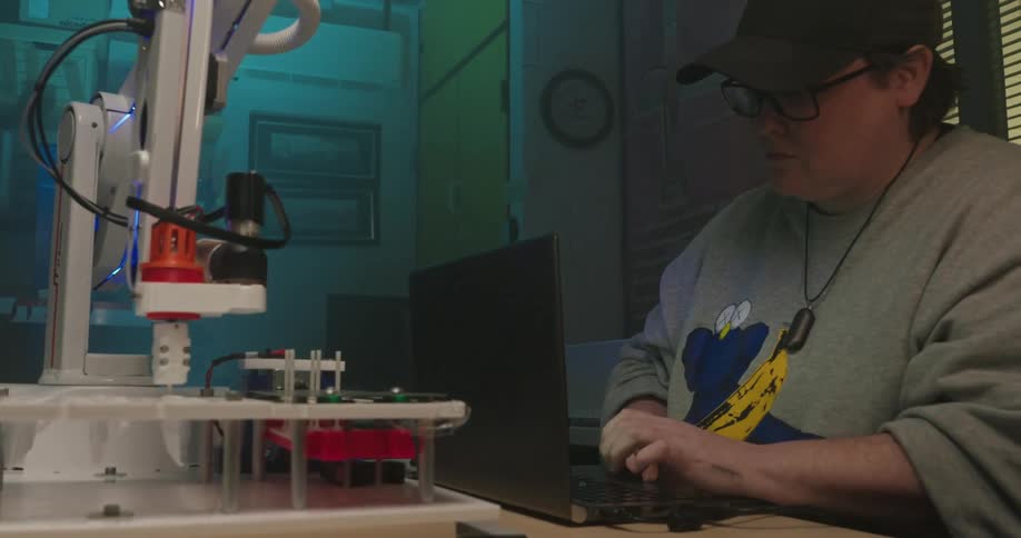 The engineer types on the computer while checking a machine