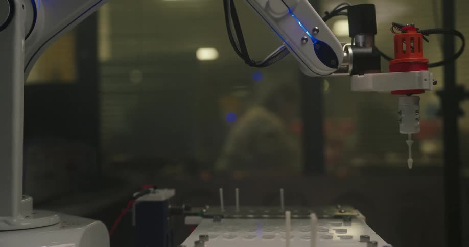 The robotic arm has a rotating needle that it is lowering