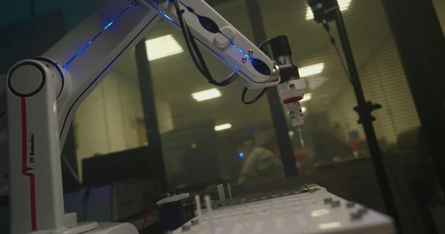 The robotic arm lowers a needle and turns back