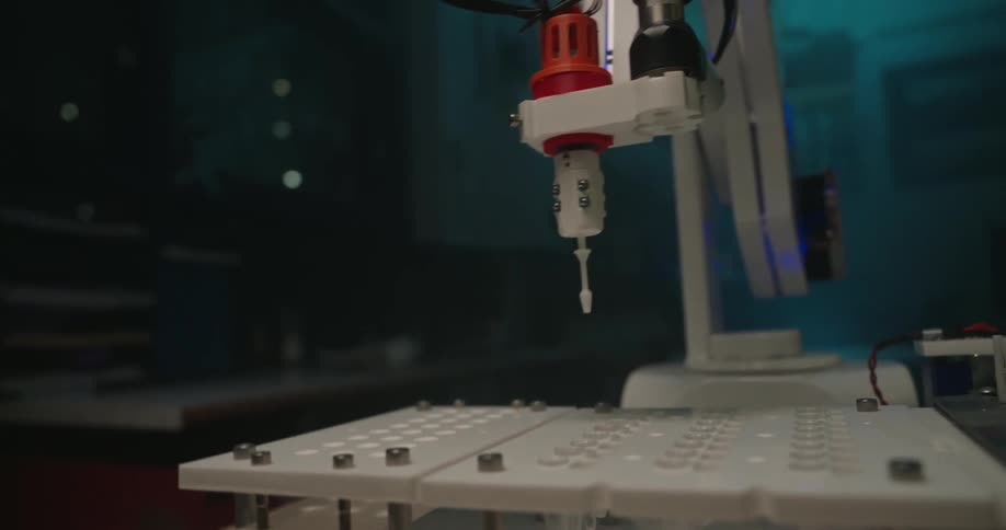Robotic arm performs operation on white platform with compartments and metal framework