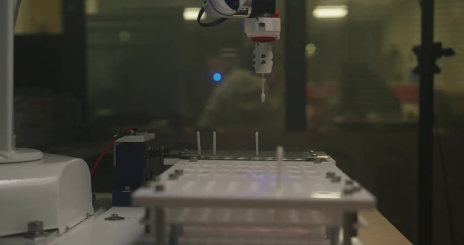 Close up of a robotic arm working on a table in a lab
