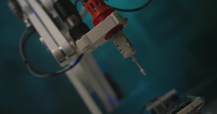 The robot inserts a white needle into the vial