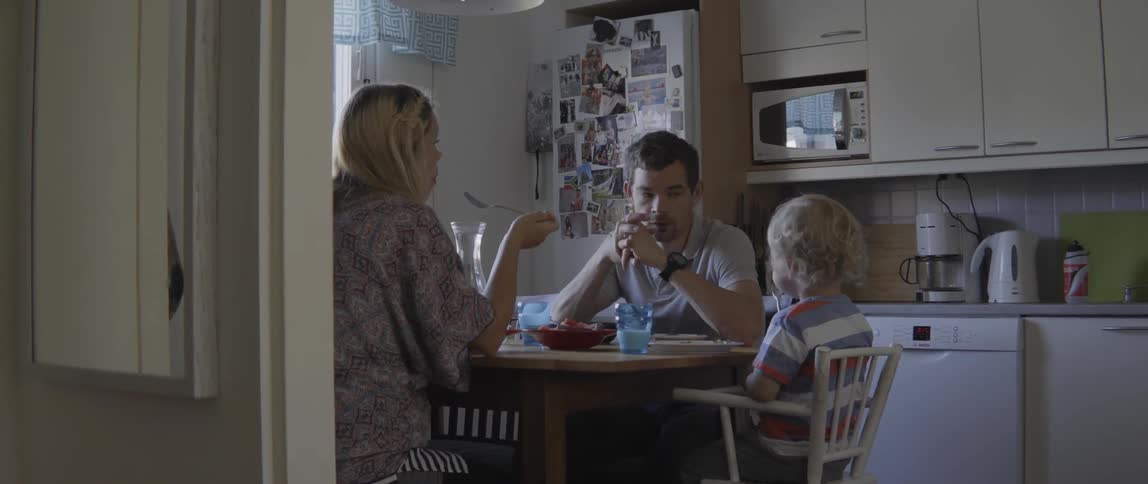 Young family bonding over a healthy lunch inside a bright and cozy kitchen setting.