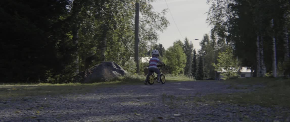 Young toddler boy enjoying an outdoor adventure on his bike during a sunny day.