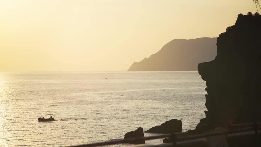 The boat passes the shore at sunrise