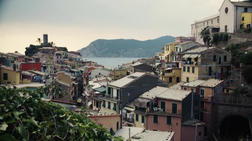 Colorful houses in a coastal village overlooking the sea with mountains in the background