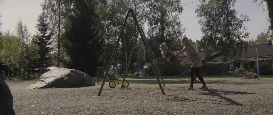 Happy mother and toddler boy enjoying a playful summer day at an outdoor playground.