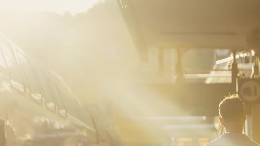 Group of people walking under intense sunlight in an urban setting