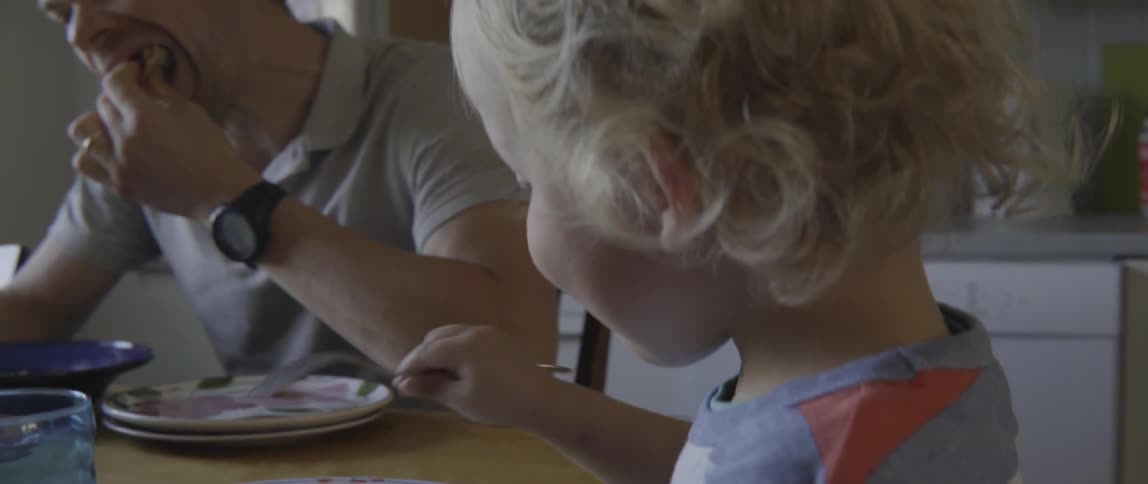 Young father, mother, and son sitting at the table for a shared meal.