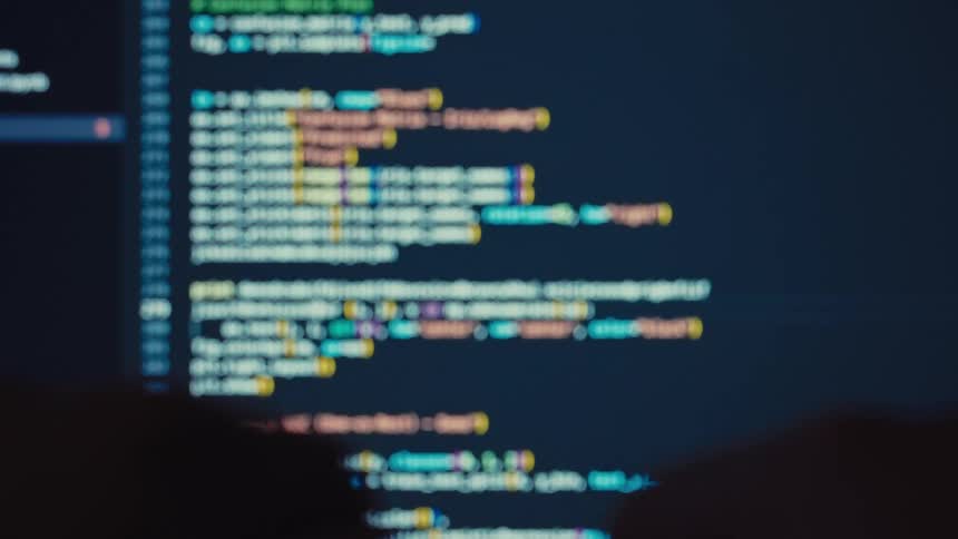 A person types a series of codes on a computer screen