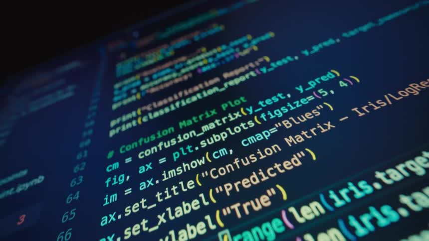 A slightly lowangle closeup shot of a laptop screen displays lines of code with bright yellow cyan and red syntax highlighting on a dark background the code appears to be python showing machine learningrelated functions such as fitting a pipeline