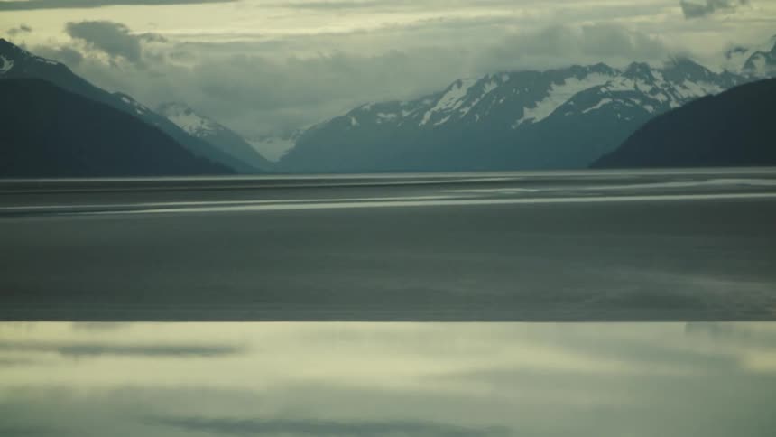 The lake is frozen over by the mountains